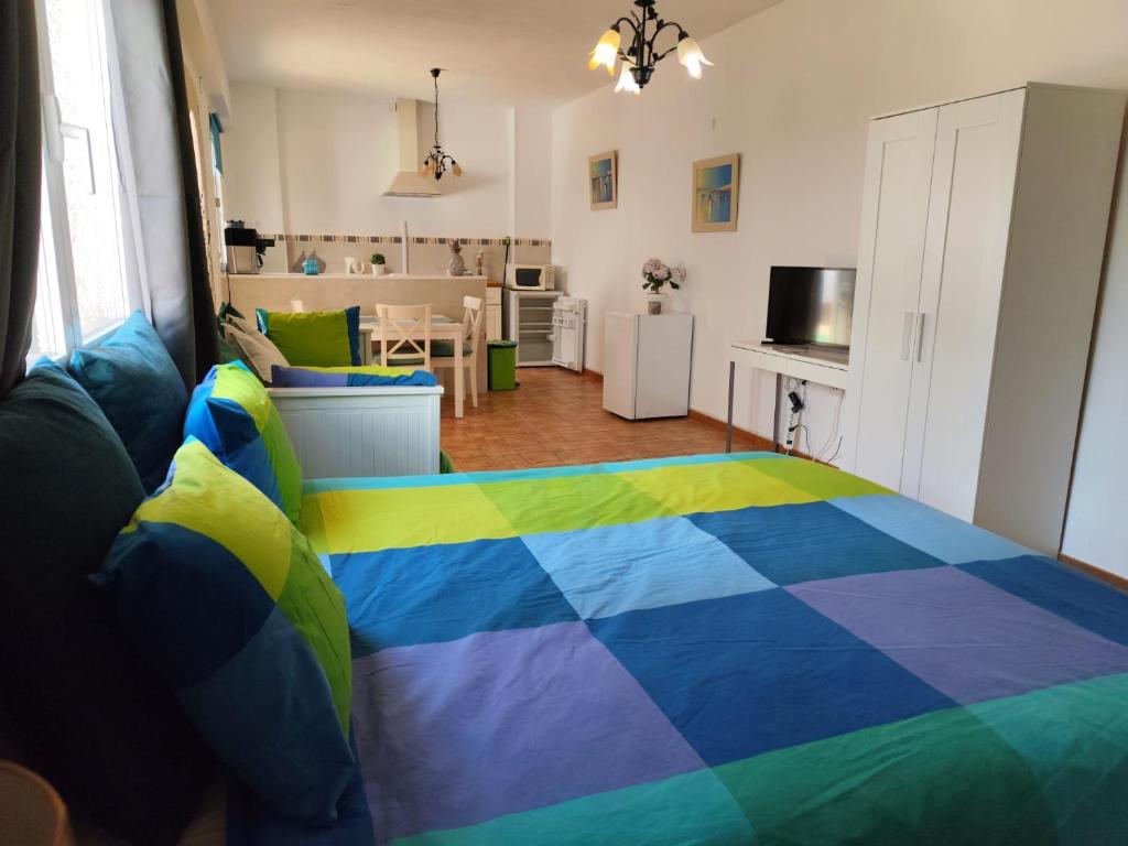 a bedroom with a colorful bed in a room at Studio Tropical in Cúllar-Vega