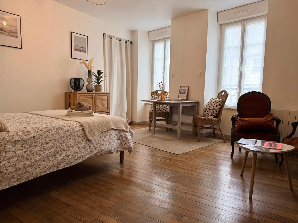 a bedroom with a bed and a table and chairs at Idéal couple & pro centre calme, wifi, proche gare in Lamballe
