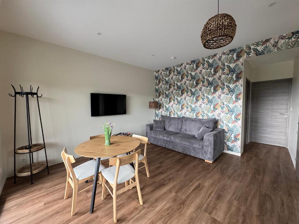 a living room with a table and a couch at Pétalya Lodge in Montcornet