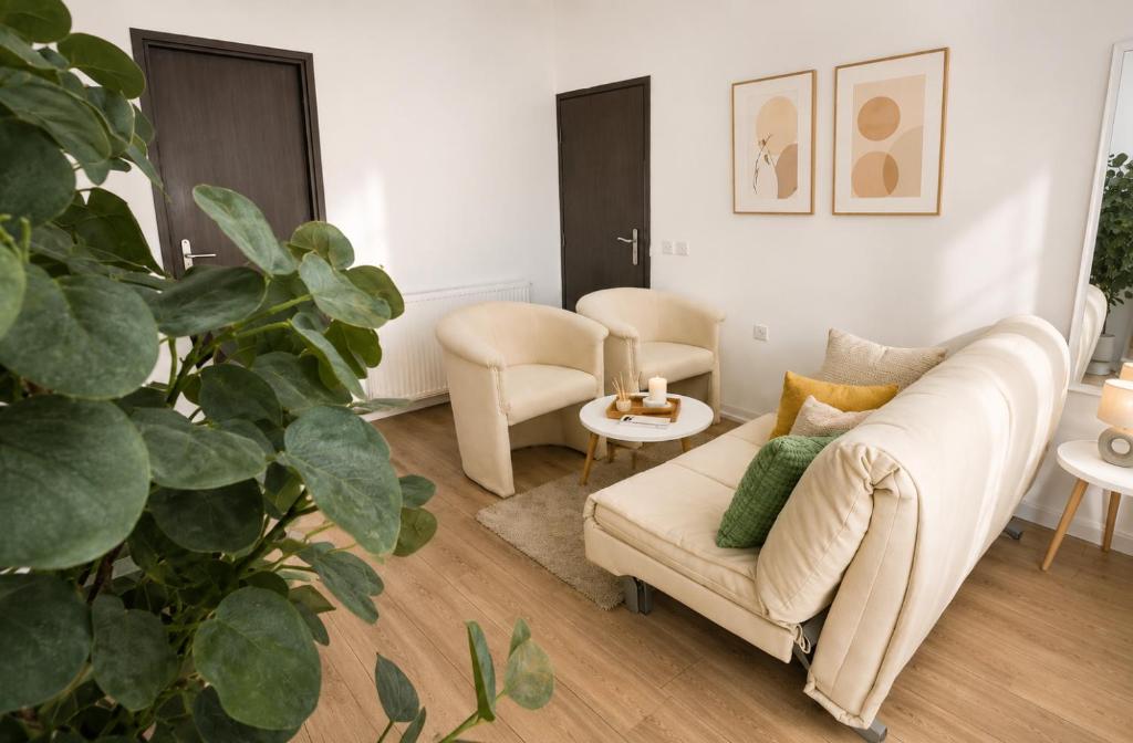 a living room with a couch and a plant at Drava Osijek in Osijek