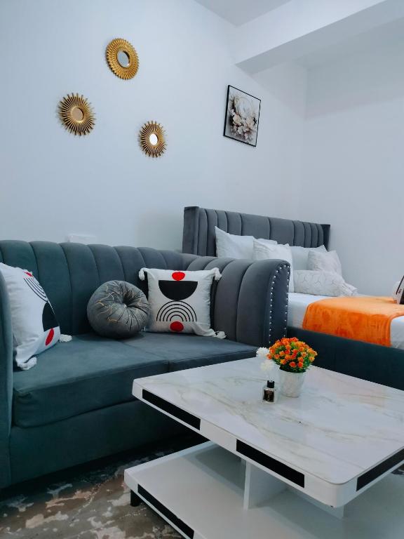 a living room with a blue couch and a table at Cutie coastal studios in Bamburi