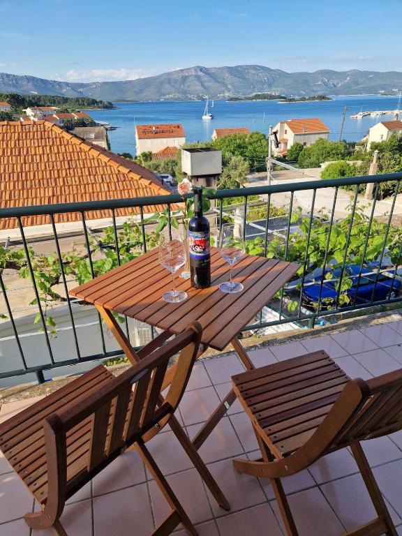 a wooden table with a bottle of wine on a balcony at Baka Jaka in Lumbarda