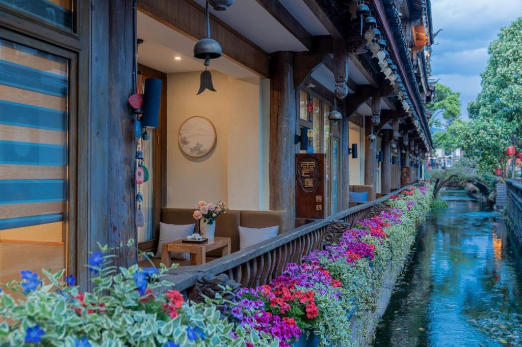 a building with flowers on the side of it at Lijiang Cloud Return Huiyi · On the Water Side Panoramic Hidden Inn (South Gate Mufu Branch) in Lijiang