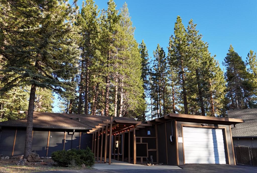 a house in the woods with a garage at Pine Haven Tahoe-Cabin with Fire Pit, Grill & EV Charger in South Lake Tahoe