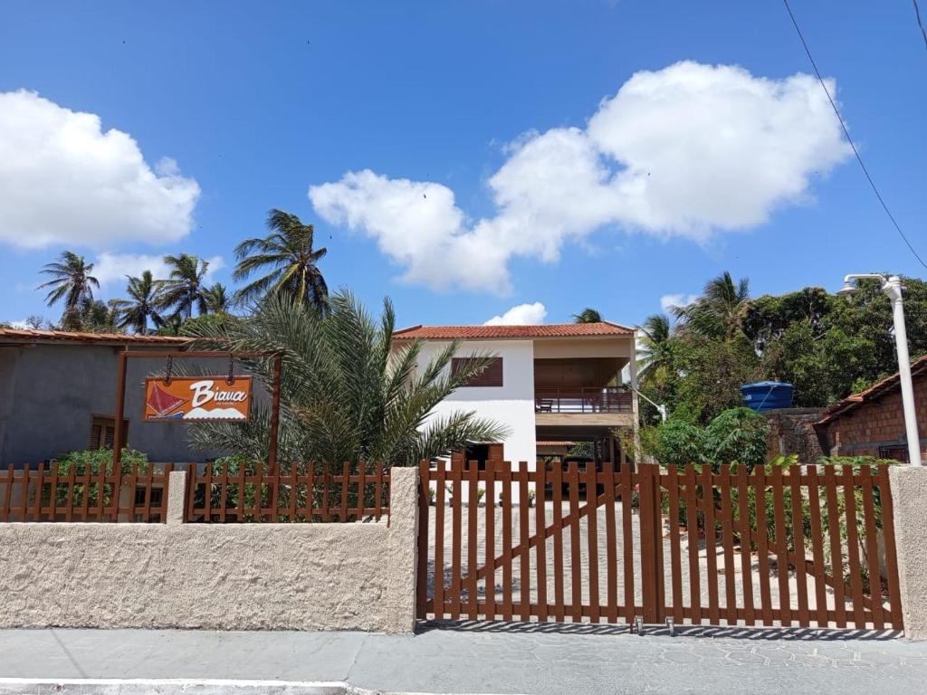 a wooden fence in front of a house at Pousada Biana Residence in Santo Amaro