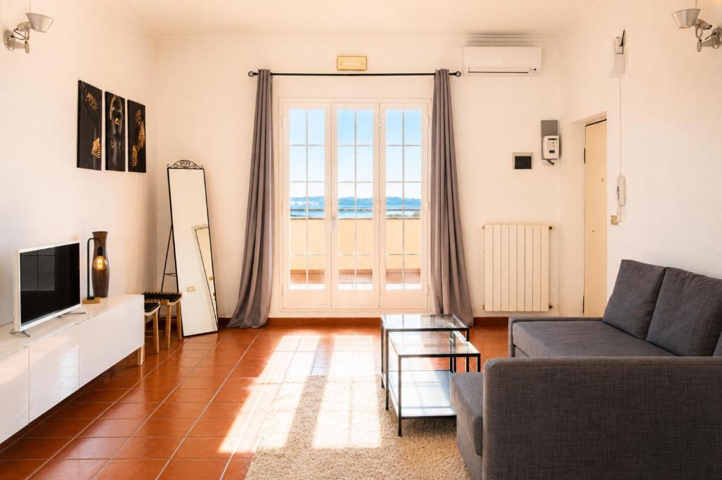 a living room with a couch and a television at Rooftop Madreperla in Taranto
