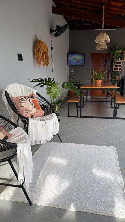 a living room with a chair and a table with plants at Casa Sol e mar in Tibau