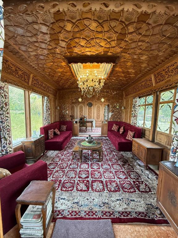 a living room with red furniture and a chandelier at Lord Palace Houseboat in Srinagar
