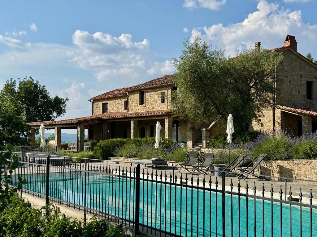 a house with a swimming pool in front of a house at Villa Podere Del Grasso in Castel del Piano