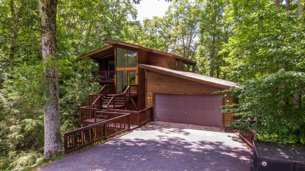 a house in the woods with a garage at Chasing Birdies in Beech Mountain