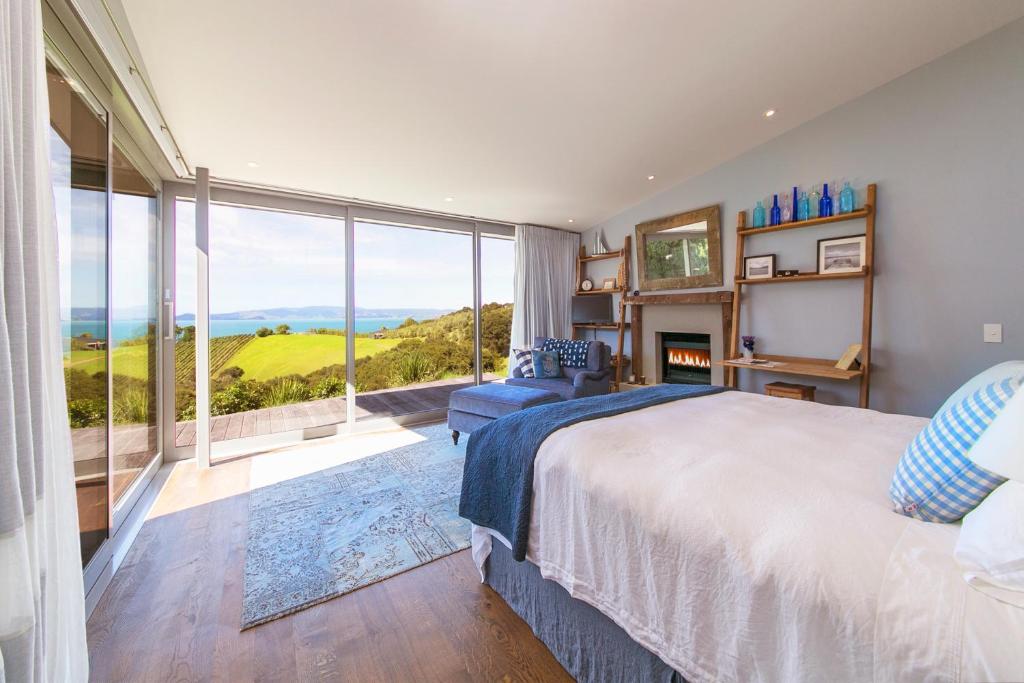 una camera con un grande letto e una grande finestra di Waiheke Luxury Blue and Green Rooms a Ostend