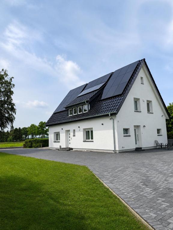 a white building with solar panels on its roof at SR Ferienwohnung Wagenfeld in Wagenfeld