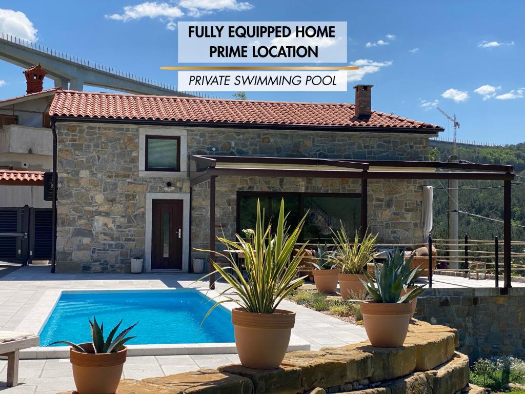 a house with a swimming pool and a patio at Bubo House in Črni Kal