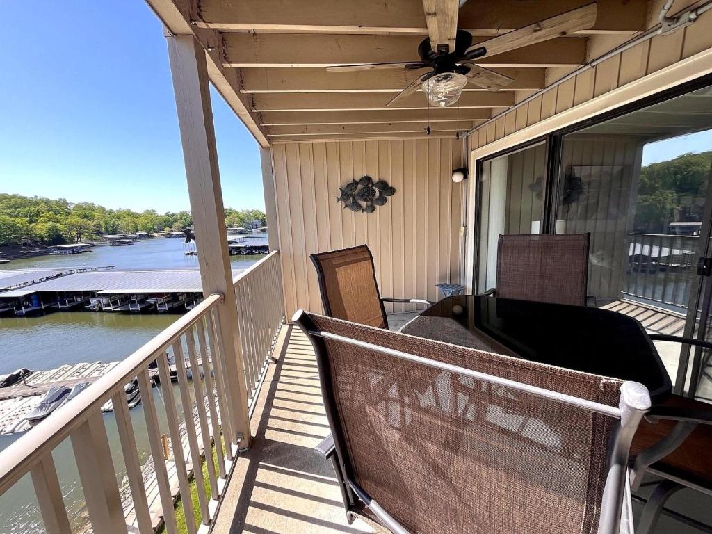 a porch with a ceiling fan and a view of a river at Serenity Pointe Boat Slip in Osage Beach