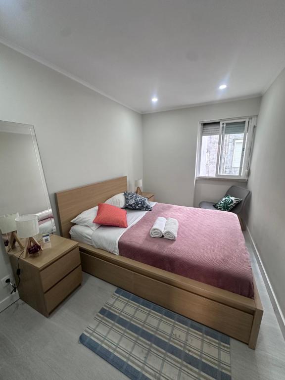 a bedroom with a large bed and a window at Rooms Moscavide quartos in Lisbon