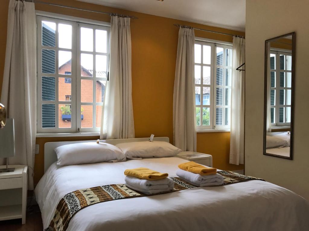 1 dormitorio con 1 cama con 2 toallas en Hotel Cayman, en Quito