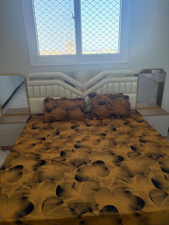 a bedroom with a large bed in a room with windows at Modern studio apartment in Mogadishu