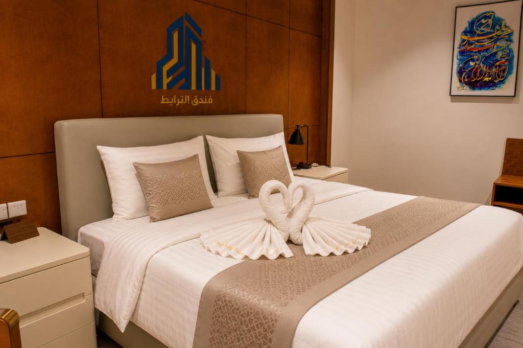 a bedroom with a bed with two towels on it at Al-TARABOT HOTEL in Muscat