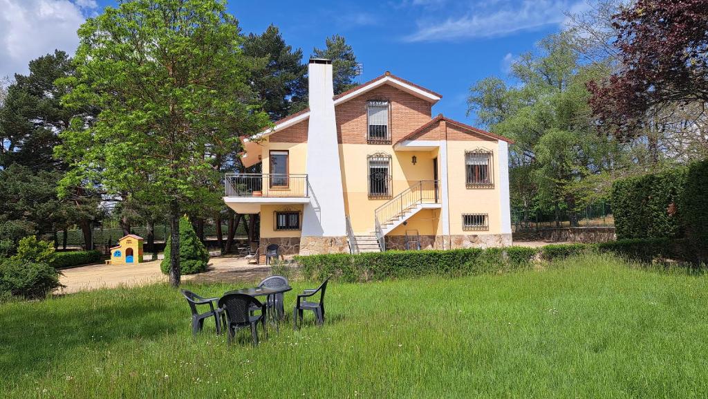 a house with a table and chairs in the grass at Chalet Pico Frentes in Cidones
