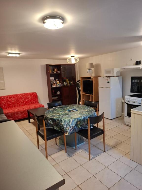 a living room with a table and a red couch at Gite saint marc in Mer