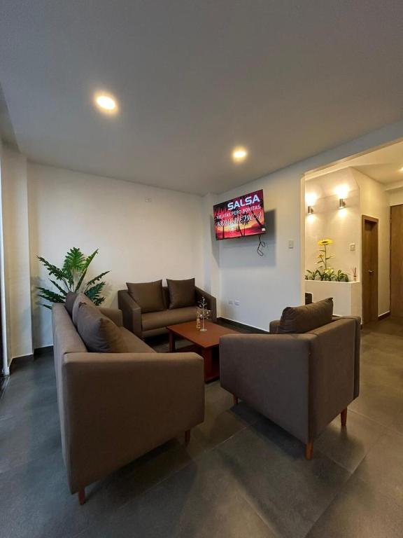 a living room with two couches and a tv at FinlandHouse in Puerto López
