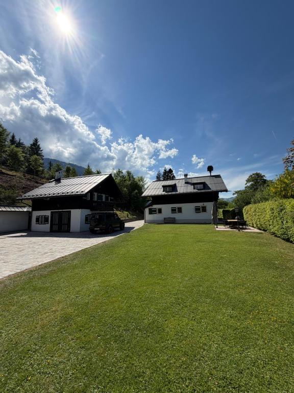 a large white house with a grass yard at ChaletFeeling im Salzkammergut in Strobl