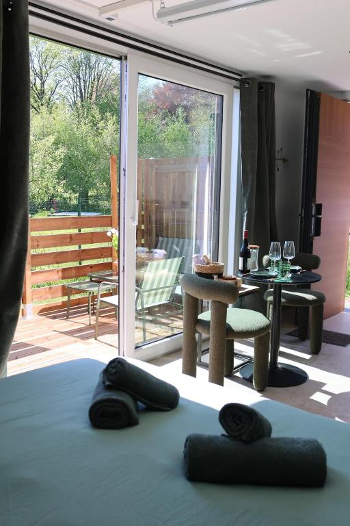 a bed with black pillows on it in a room with a patio at Le Nid du Cortil in Theux