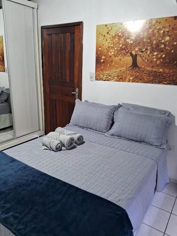 a bed in a bedroom with a painting on the wall at Loft em São José in São José