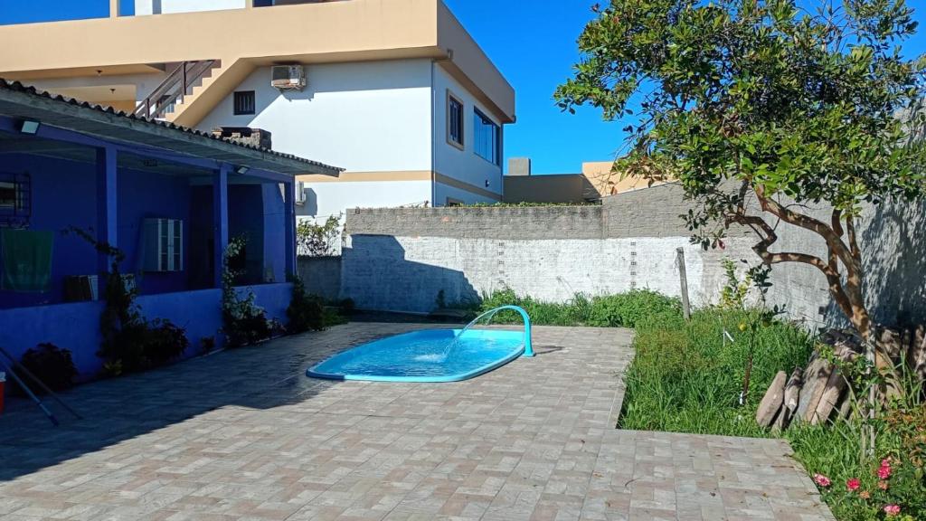 a swimming pool in a yard next to a house at CasaZita in Passo De Torres