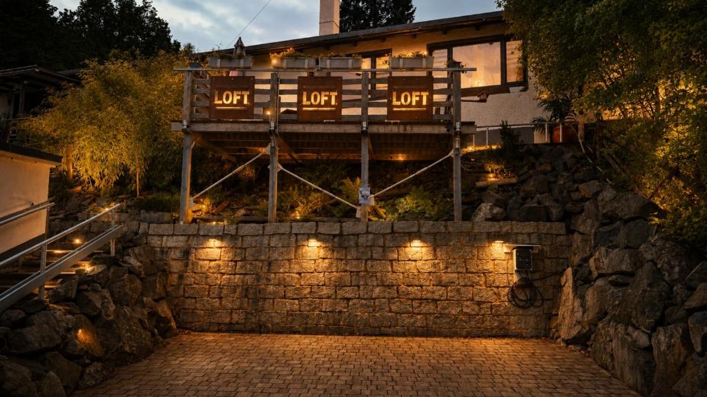 a house with lights on a stone wall at FichtelLOFT Retreat-Design Loft nahe Bayreuth in Goldkronach