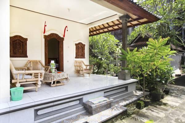 un patio de una casa con sillas y mesa en Koming House, en Ubud