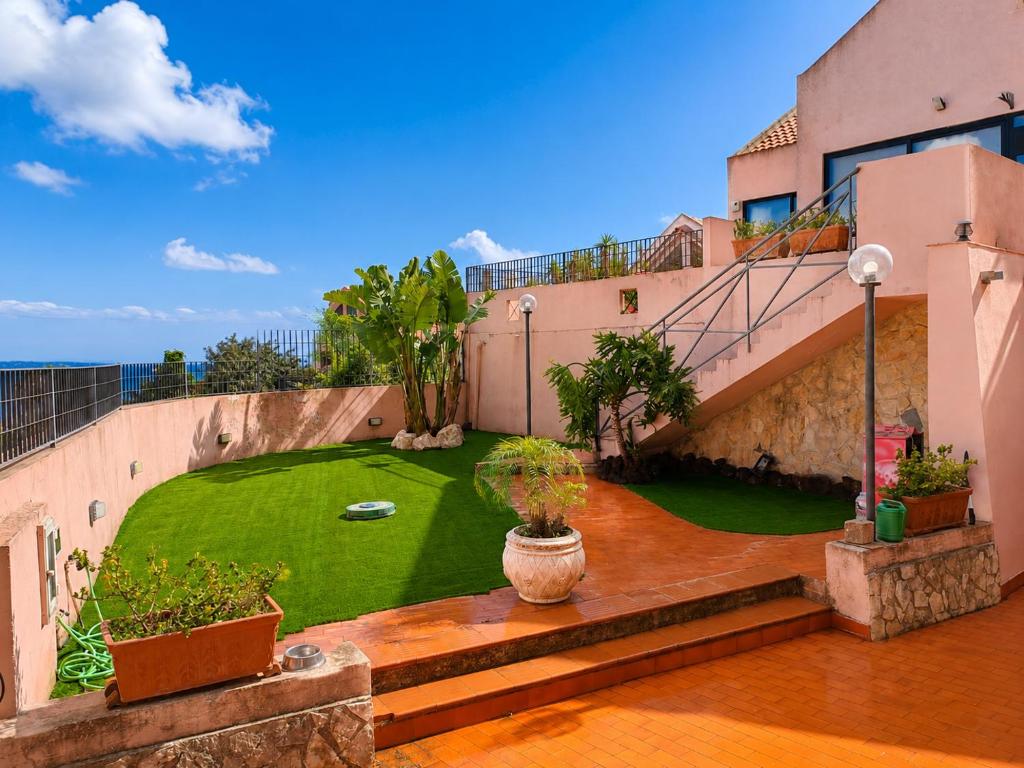 an apartment with a green yard on a building at Aloha Village - Bed&Pet in Messina