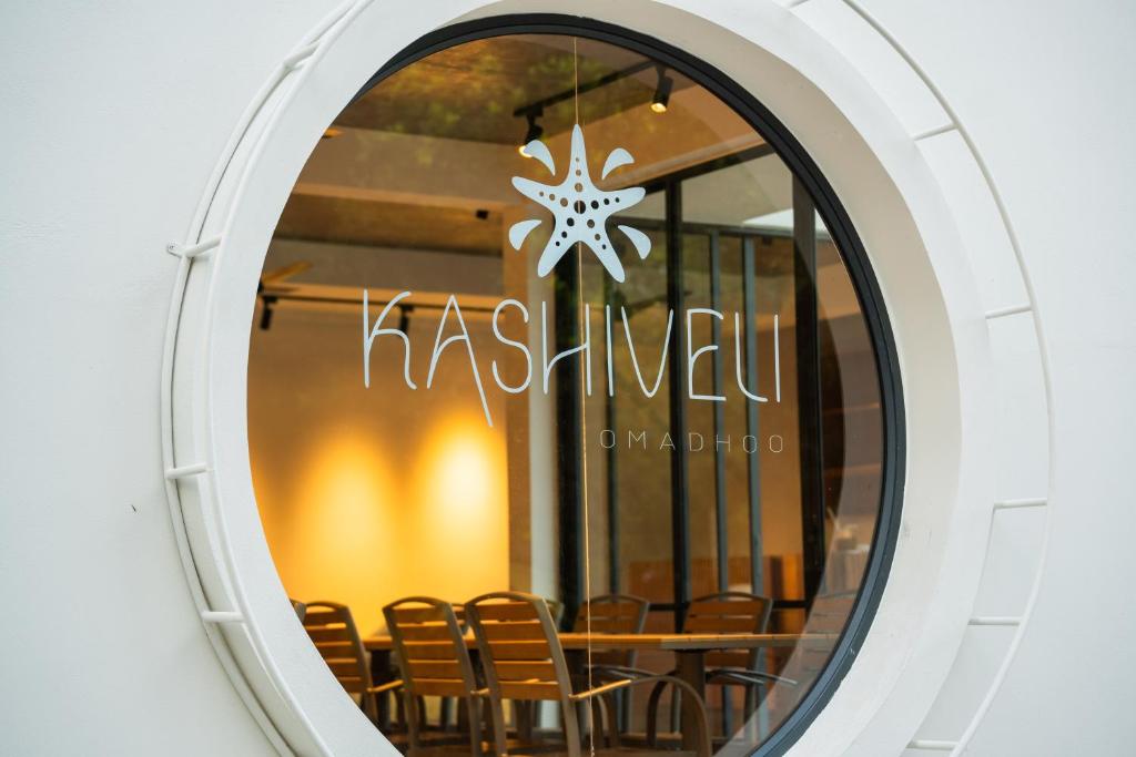 a round window with a table and chairs at Kashiveli Omadhoo in Omadhoo