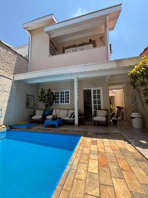 a villa with a swimming pool in front of a house at Harmonia e Paz in São José dos Campos