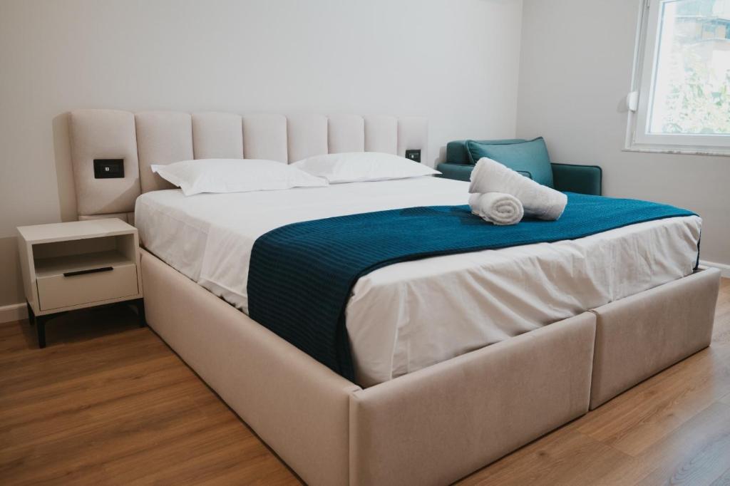 a large white bed with a blue blanket on it at Shehu Skenderbeg Stay in Tirana