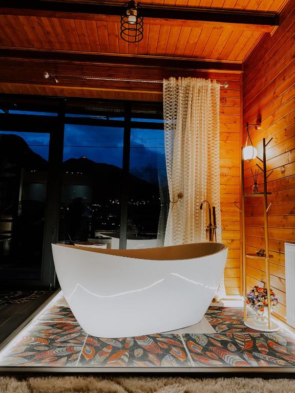 a large white bath tub in a room with a window at Omenor Kazbegi in Kazbegi