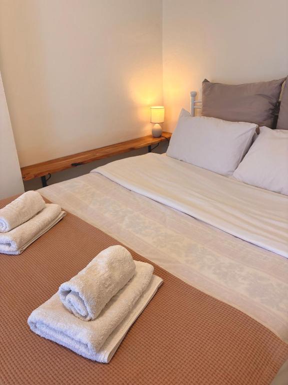 a bedroom with two beds with towels on the floor at Port Breeze Apartments in Karlovasi