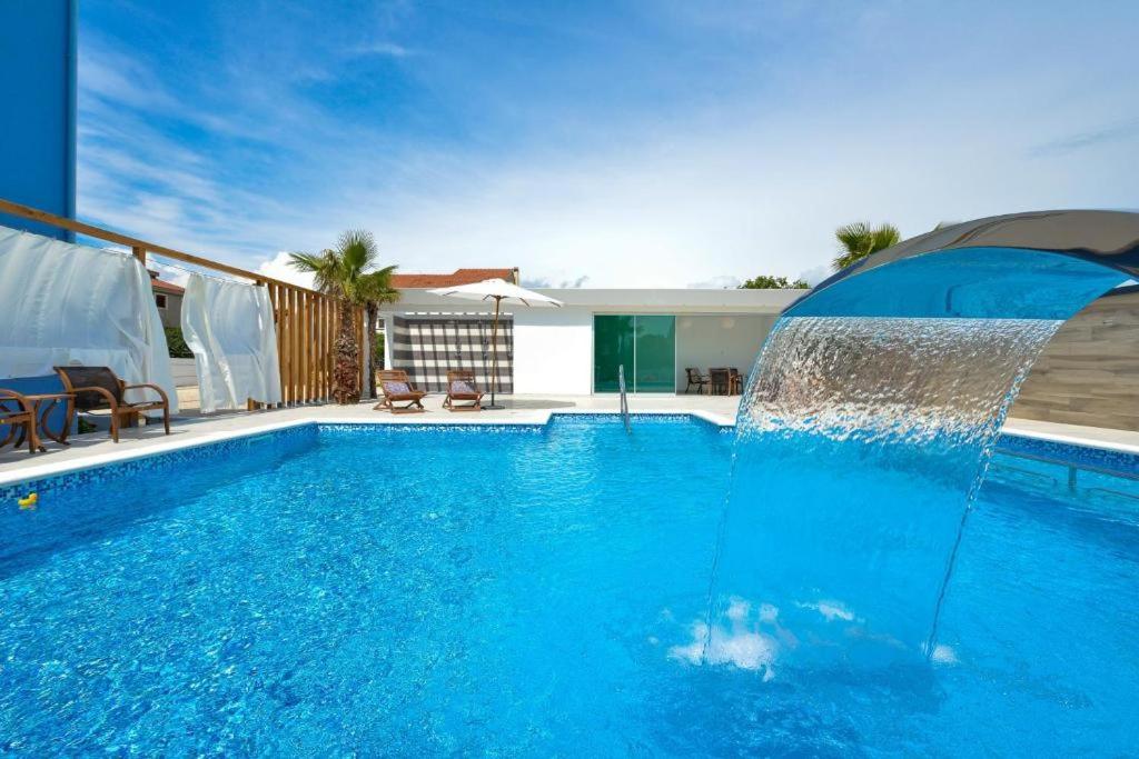 a large swimming pool with a water fountain at Apartmani Novia in Bibinje