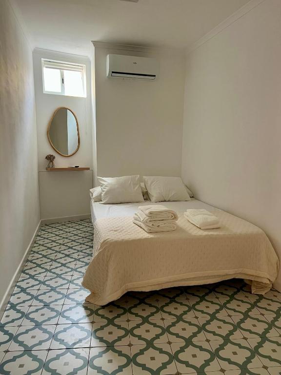 a bedroom with a bed and a mirror on the wall at Elvas Centro Histórico Largo do Refúgio in Elvas