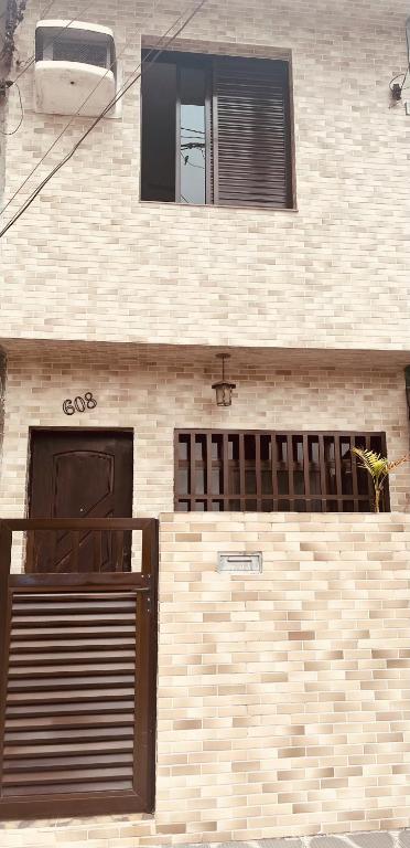 a brick building with two doors and a window at Casa na Ponta da Praia - Quintais privativos, churrasqueira e Wi-fi - Até 6 hospedes in Santos