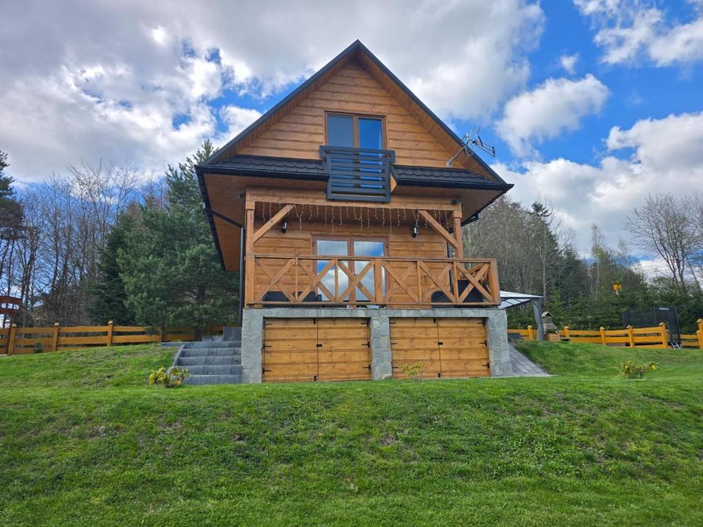 a small house on top of a green field at Domek na Czerwonej Górce in Uście Gorlickie