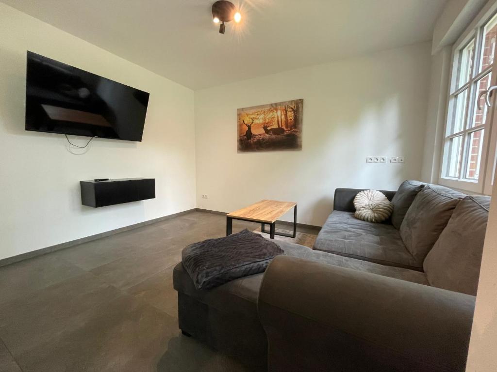 a living room with a couch and a flat screen tv at Ruhige Monteurwohnung Ohrtermersch in Bippen