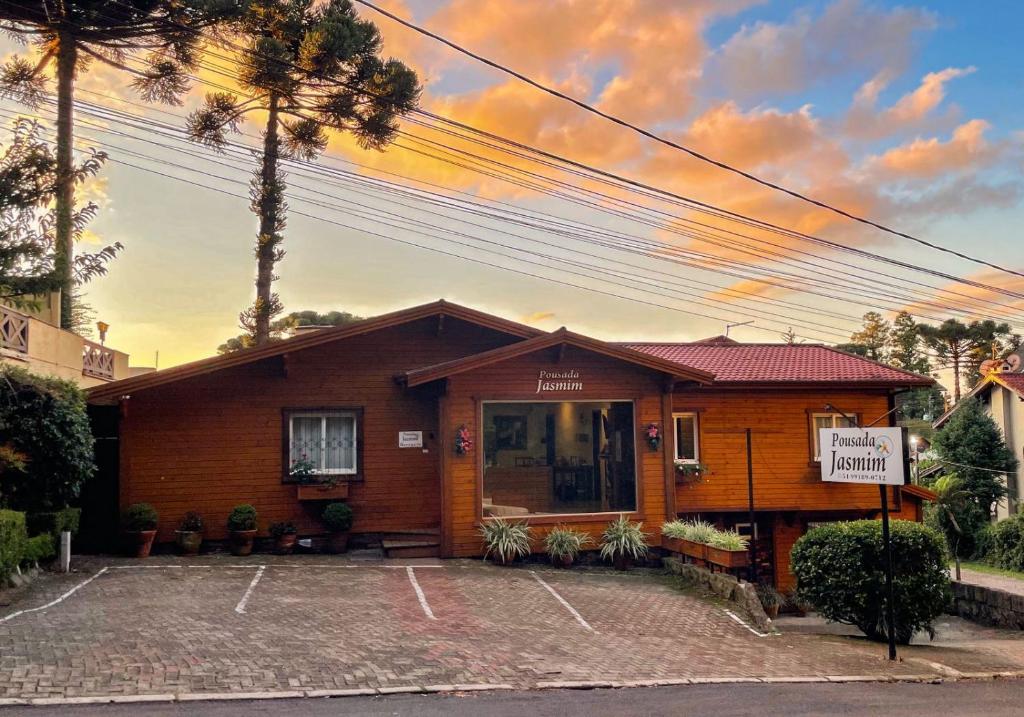 a building with a parking lot in front of it at Pousada Jasmim in Gramado