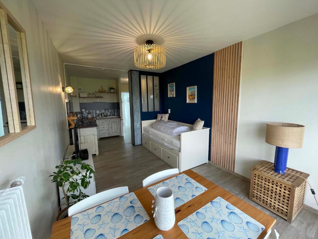 a living room with a bed and a table at Studio face mer L'escapade marine in Calais
