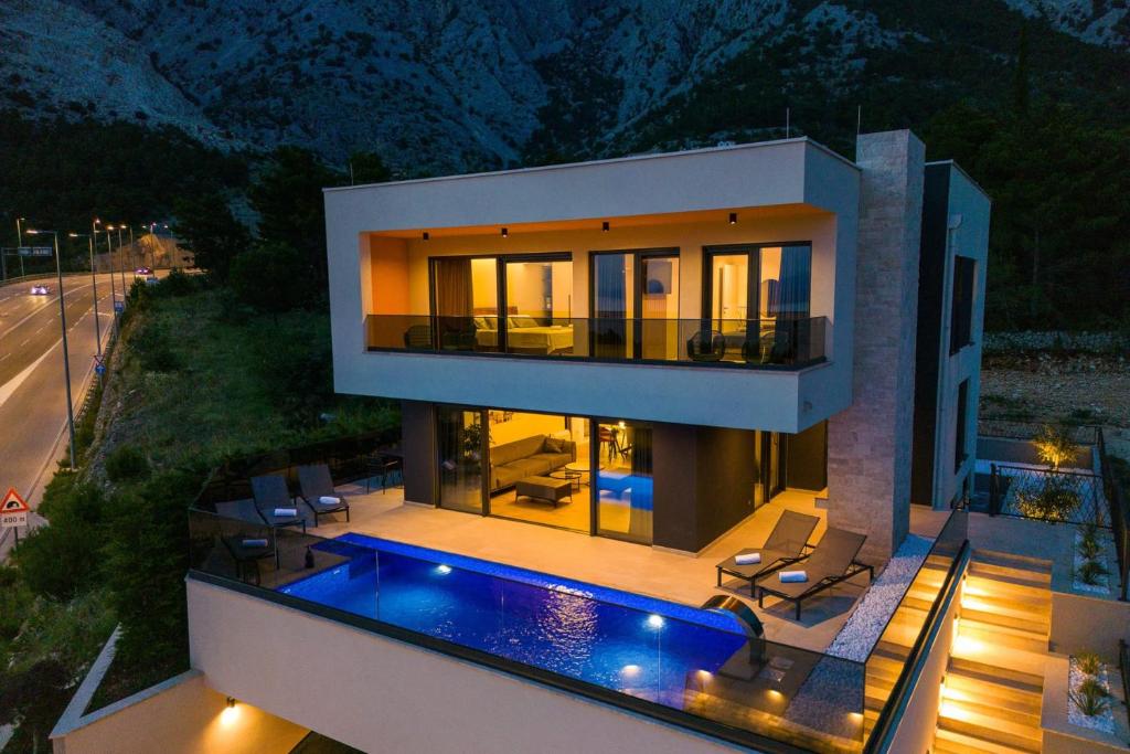 a house with a swimming pool at night at Luxury Villa Sirius, Bast, Makarska Rivijera in Bast
