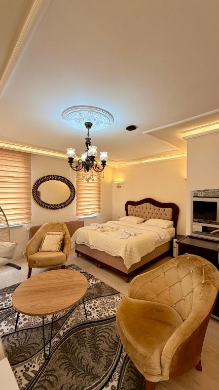 a bedroom with a bed and a chandelier at İsgobya Dağ Evleri 101 in Macka