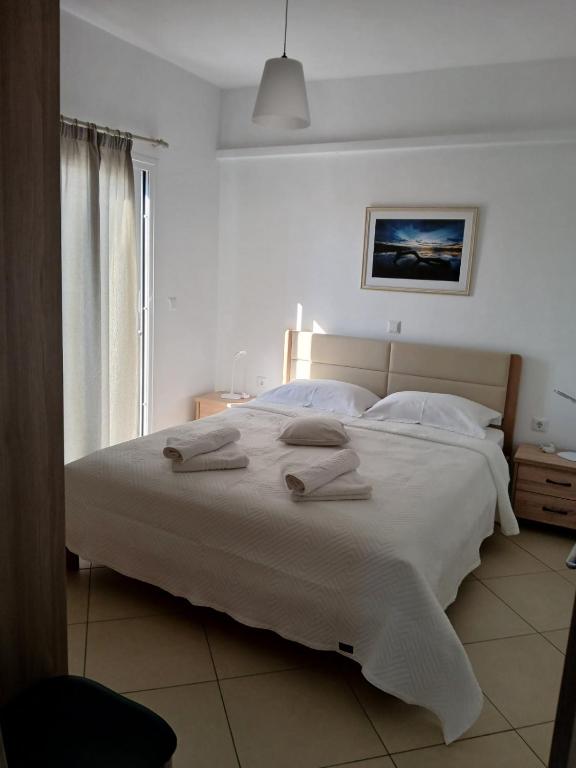 a bedroom with a large white bed with towels on it at Niko's apartments 1 in Elafonisos