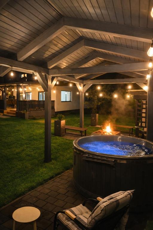 a hot tub in a yard with a pergola at Vila Luna Valea Avrigului in Avrig