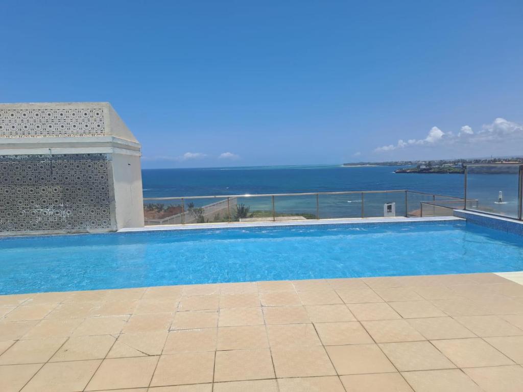 a swimming pool with a view of the ocean at Seaview SS palm terrace serviced apt-nyali in Mombasa