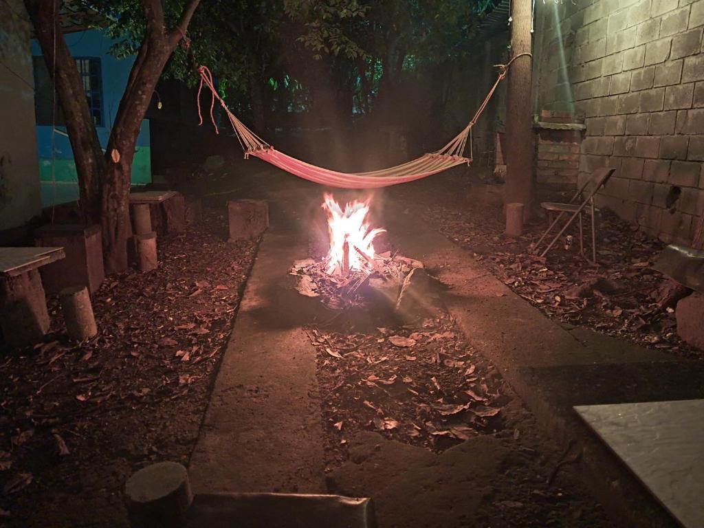 a hammock is hanging over a fire in a yard at Hostal Juan Lindo in San Pedro Sula
